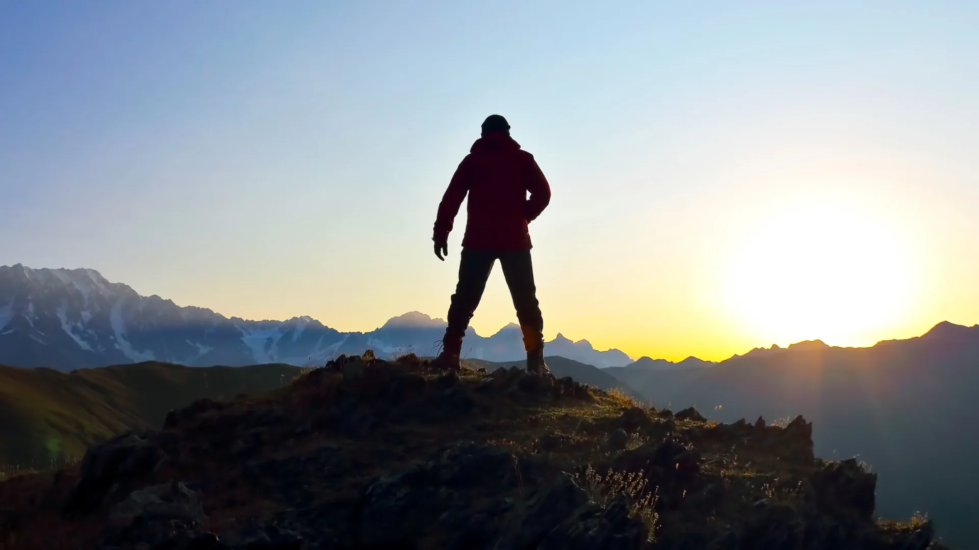 Bergsteiger mit Blick über eine Berglandschaft